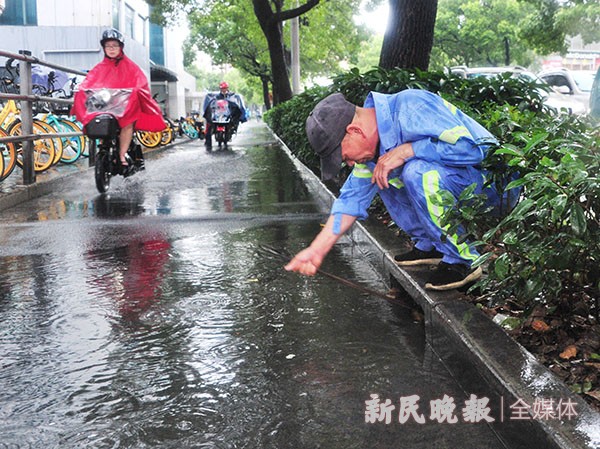 道路积水不退 他用手疏通