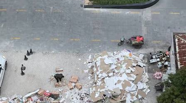 商业广场建筑垃圾临时堆放点离居民家一墙之隔 多年来粉尘噪声扰民何时休？