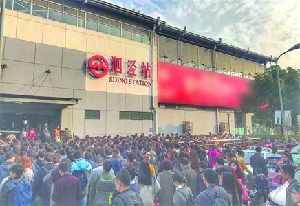 图说:早高峰时段,9号线泗泾站站外客流密集,护栏内人群行进速度缓慢.