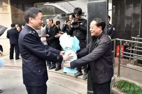 图说:青浦公安分局局长王德强向刑侦支队专案组民警李庆献花.